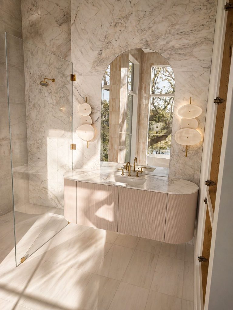 marble wall with custom marble vanity, glass shower doors and mirror